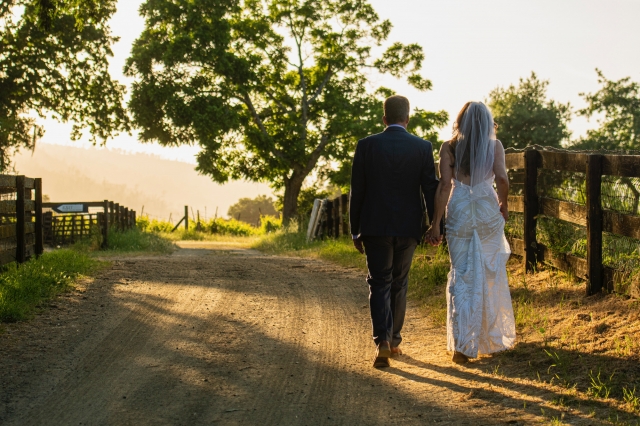 Newly weds walking down the path at sunset